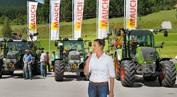 Susanne Mauch-Authenriet mit Mikrofon in der Hand vor verschiedenen Fendt Vario Traktoren