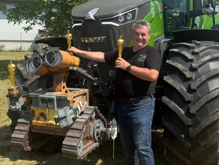 Gerd Nefzer mit seinen 3 Oscars vor seinem Fendt 900 Vario und Wall-e aus dem Film