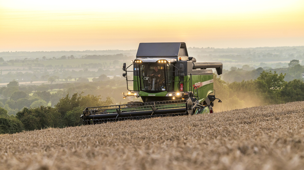 Fendt Combine L Series 5255 threshing grain in the sunset side view