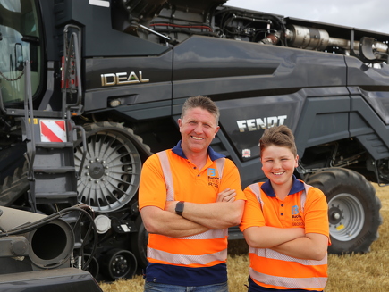 Family father Buckle and his son stand in front of their black Fendt IDEAL 9T