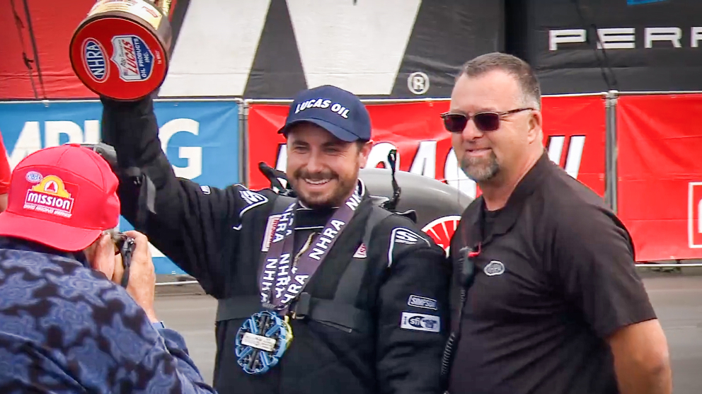 Fendt Race Car Driver Holding Trophy at NHRA Race