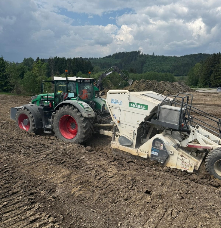 Fendt tractor with a soil stabilization machine improving soil structure and preparing the ground for construction work. The machine is used for efficient soil stabilization and subgrade preparation.
