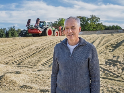Tuotantopäällikkö Jörg Henke silonsa edessä, taustalla vihreä Fendt-traktori