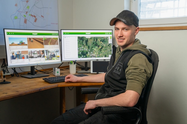 Tim Satzger sitter ved skrivebordet. På skrivebordet stor det to dataskjermer. Han ser inn i kameraet.