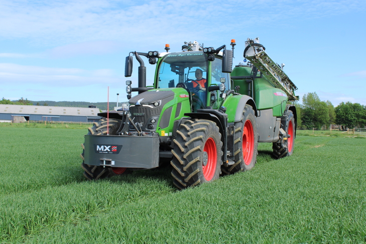 Matthew Mackay kjører en grønn Fendt 620 Vario med røde felger og en Rogator på slep over en åker