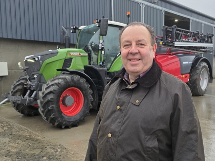 Murray Forsyth står leende framför en grön Fendt 724 Vario Gen7 med röda fälgar